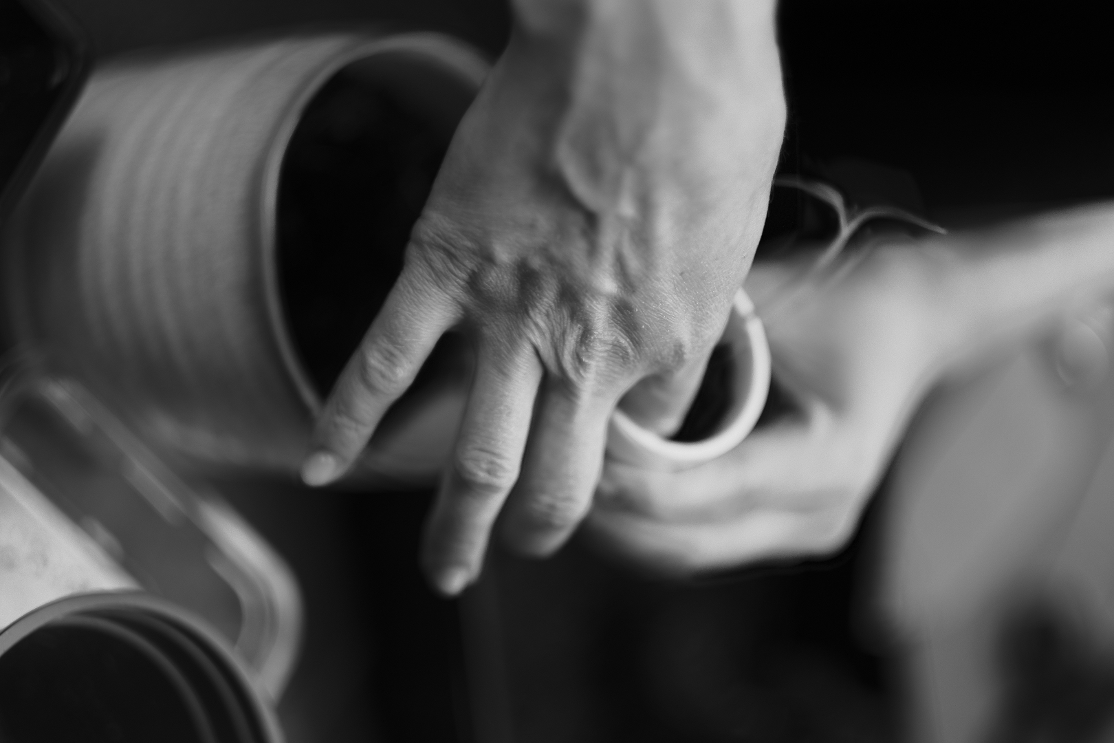Hands planting seeds in a small pot — the slow beginning of growth